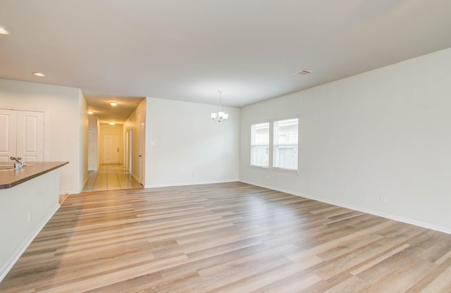 3102 Gianna Springs Ct, Humble, TX 77396 - empty room featuring a chandelier, light wood finished floors, recessed lighting, and baseboards