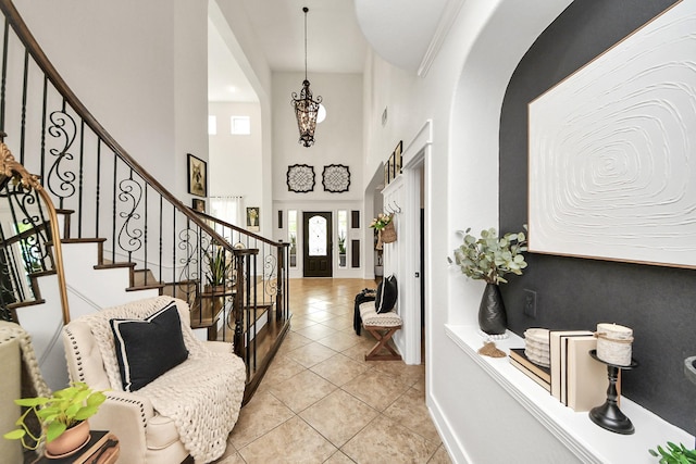 19910 Standing Cypress Dr, Spring, TX 77379 - foyer featuring arched walkways, light tile patterned flooring, stairway, a towering ceiling, and baseboards