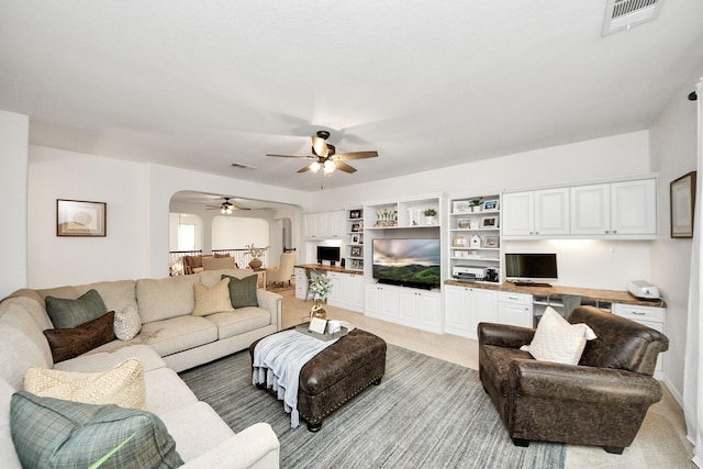 19910 Standing Cypress Dr, Spring, TX 77379 - living room with arched walkways, ceiling fan, and light colored carpet