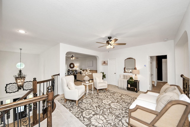 19910 Standing Cypress Dr, Spring, TX 77379 - living room with light colored carpet, ceiling fan, arched walkways, and a chandelier
