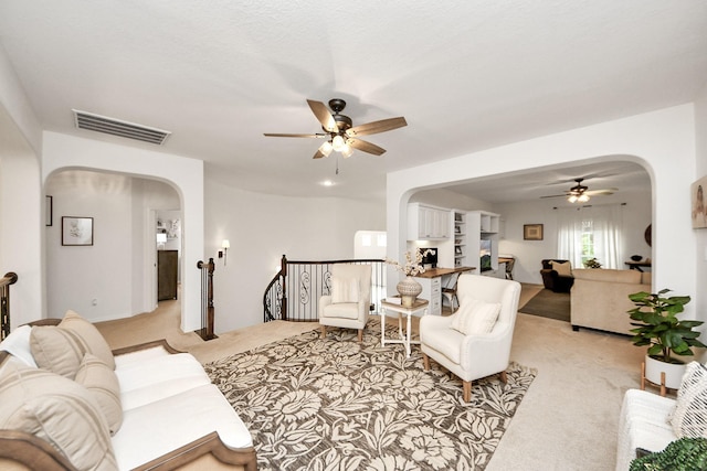 19910 Standing Cypress Dr, Spring, TX 77379 - living room featuring arched walkways, ceiling fan, and light colored carpet
