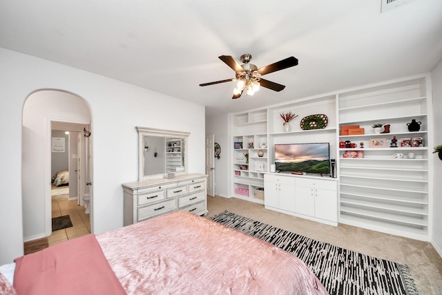 19910 Standing Cypress Dr, Spring, TX 77379 - bedroom with arched walkways, light colored carpet, connected bathroom, ceiling fan, and baseboards