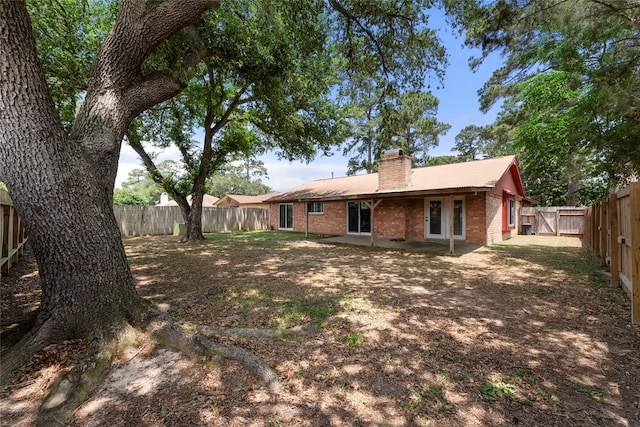 3531 Acorn Springs Ln, Spring, TX 77389 - rear view of property featuring brick siding, a chimney, a fenced backyard, and a patio area