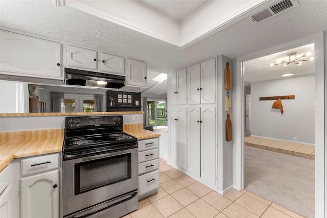 3531 Acorn Springs Ln, Spring, TX 77389 - kitchen featuring stainless steel electric range oven, extractor fan, light tile patterned flooring, white cabinetry, and light carpet