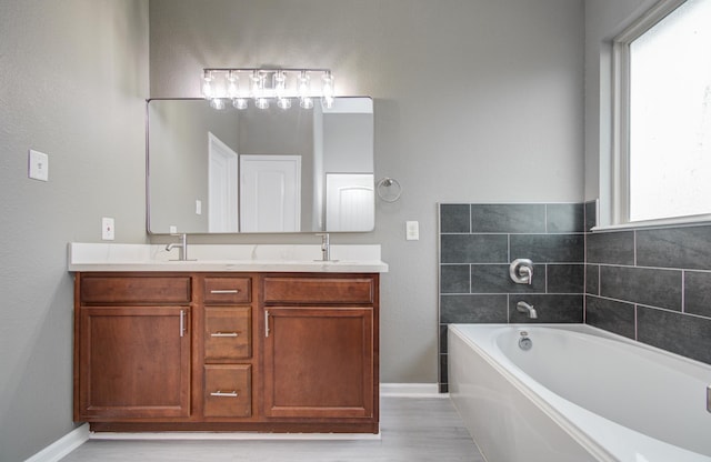15303 Arnold, Baytown, TX 77523 - bathroom with baseboards, double vanity, a garden tub, and wood finished floors