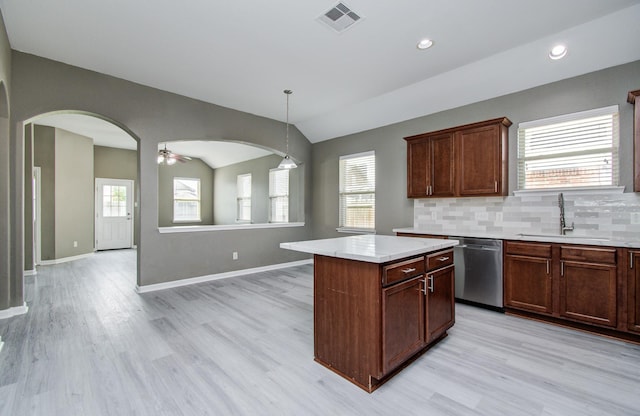 15303 Arnold, Baytown, TX 77523 - kitchen with dishwasher, a sink, arched walkways, lofted ceiling, and light wood-style flooring