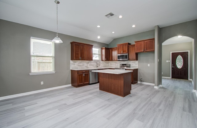 15303 Arnold, Baytown, TX 77523 - kitchen featuring stainless steel appliances, decorative backsplash, light wood-style flooring, a kitchen island, and light countertops