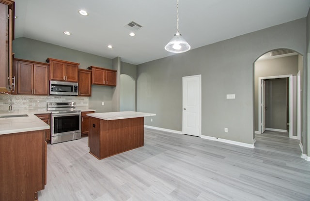 15303 Arnold, Baytown, TX 77523 - kitchen with appliances with stainless steel finishes, arched walkways, light wood-style flooring, a center island, and recessed lighting