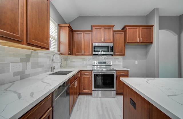 15303 Arnold, Baytown, TX 77523 - kitchen featuring appliances with stainless steel finishes, a sink, light stone countertops, light wood-type flooring, and lofted ceiling