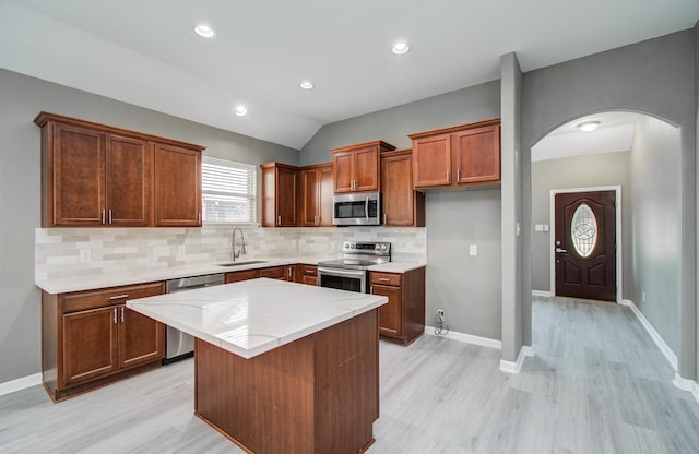 15303 Arnold, Baytown, TX 77523 - kitchen with appliances with stainless steel finishes, a sink, arched walkways, light wood-type flooring, and backsplash