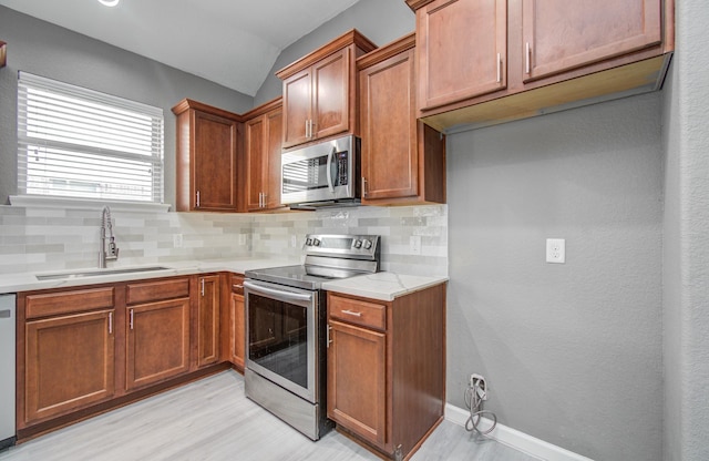15303 Arnold, Baytown, TX 77523 - kitchen featuring stainless steel appliances, a sink, vaulted ceiling, tasteful backsplash, and light wood-type flooring