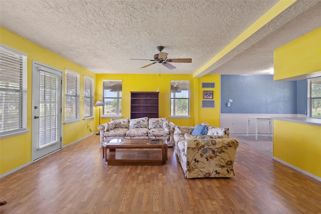 25 Willey Rd, Bedias, TX 77831 - living room featuring wood finished floors, ceiling fan, a textured ceiling, healthy amount of natural light, and beam ceiling