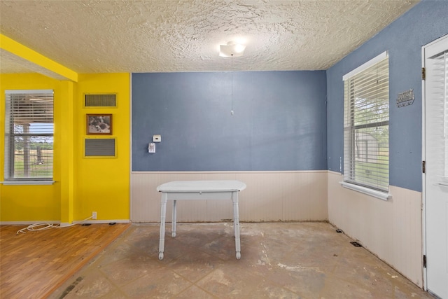 25 Willey Rd, Bedias, TX 77831 - unfurnished dining area featuring a wainscoted wall and a textured ceiling