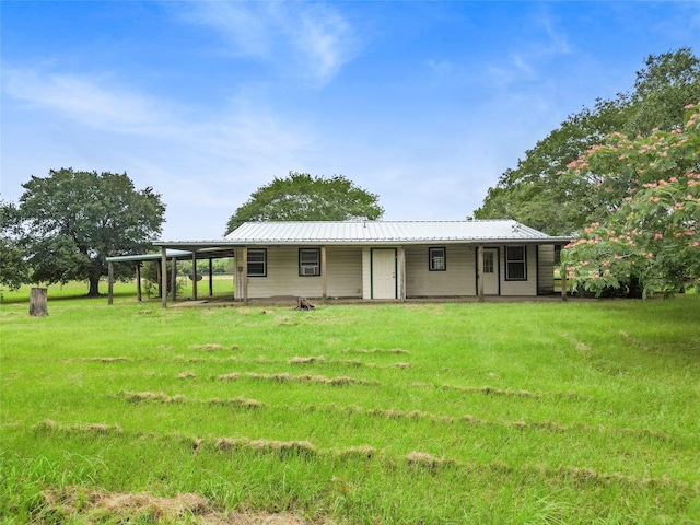 25 Willey Rd, Bedias, TX 77831 - back of property with metal roof, a yard, and an attached carport