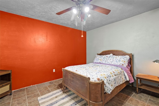 25 Willey Rd, Bedias, TX 77831 - bedroom with a textured ceiling, ceiling fan, and stone finish floors