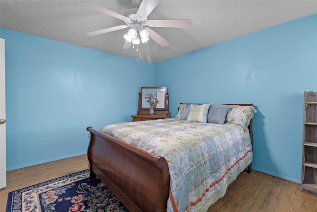 25 Willey Rd, Bedias, TX 77831 - bedroom with baseboards, wood finished floors, a textured ceiling, and a ceiling fan