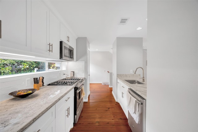 668 Lester St, Houston, TX 77007 - kitchen with appliances with stainless steel finishes, a sink, dark wood-style floors, decorative backsplash, and recessed lighting