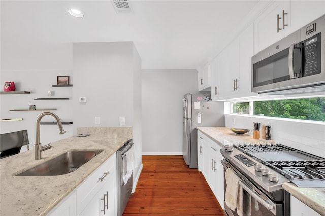 668 Lester St, Houston, TX 77007 - kitchen featuring appliances with stainless steel finishes, a sink, dark wood-style floors, tasteful backsplash, and baseboards