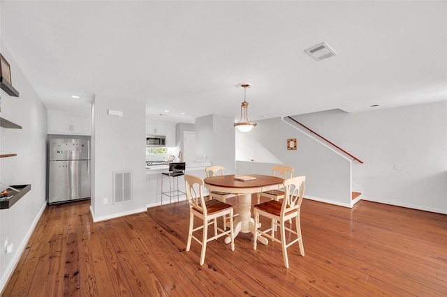 668 Lester St, Houston, TX 77007 - dining area with hardwood / wood-style floors, stairs, baseboards, and recessed lighting