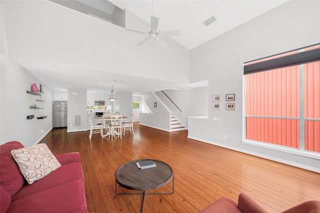 668 Lester St, Houston, TX 77007 - living area featuring stairway, a ceiling fan, hardwood / wood-style flooring, baseboards, and high vaulted ceiling