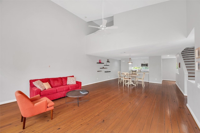 668 Lester St, Houston, TX 77007 - living area featuring stairs, hardwood / wood-style floors, baseboards, a high ceiling, and ceiling fan