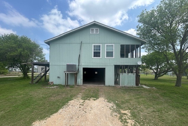 501 S 15th St, Seadrift, TX 77983 - view of property exterior featuring driveway, a lawn, stairway, and central AC