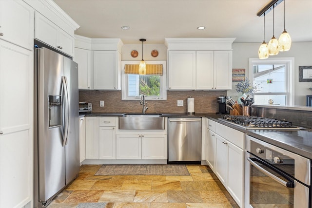 210 Queen Rd, Clear Lake Shores, TX 77565 - kitchen featuring appliances with stainless steel finishes, a sink, dark countertops, white cabinetry, and plenty of natural light