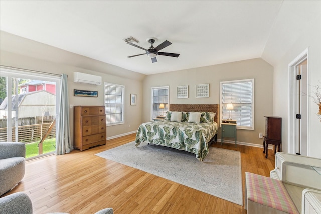 210 Queen Rd, Clear Lake Shores, TX 77565 - bedroom with an AC wall unit, light wood finished floors, multiple windows, baseboards, and vaulted ceiling