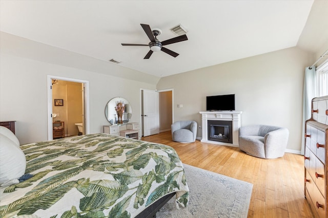 210 Queen Rd, Clear Lake Shores, TX 77565 - bedroom with lofted ceiling, light wood-style flooring, a fireplace, ceiling fan, and baseboards