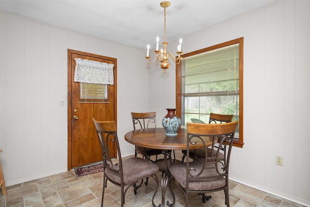 111 Ann St, Crockett, TX 75835 - dining room with a chandelier, crown molding, baseboards, stone finish flooring, and a decorative wall