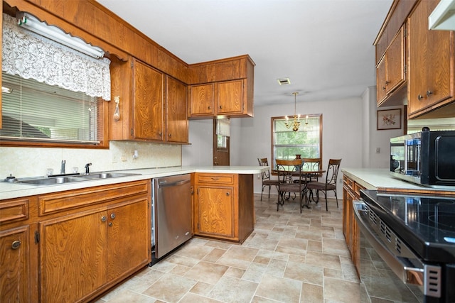 111 Ann St, Crockett, TX 75835 - kitchen with appliances with stainless steel finishes, brown cabinets, light countertops, stone finish flooring, and a peninsula