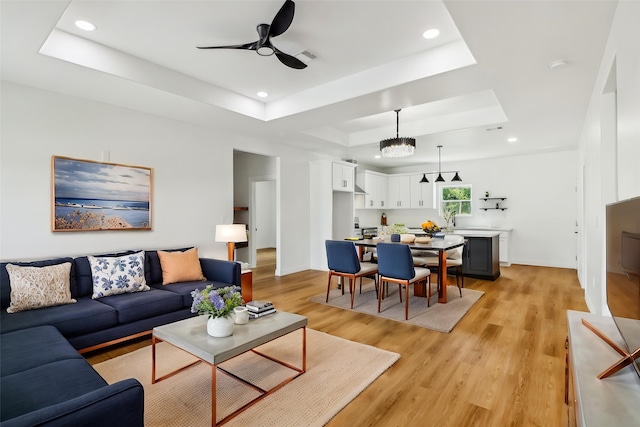16731 Water Oak Dr, Channelview, TX 77530 - living room with a tray ceiling, recessed lighting, ceiling fan, light wood-style floors, and baseboards