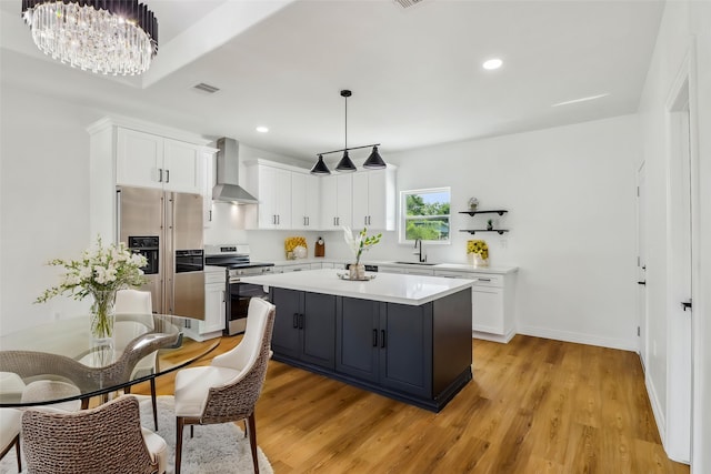 16731 Water Oak Dr, Channelview, TX 77530 - kitchen with appliances with stainless steel finishes, wall chimney exhaust hood, white cabinetry, light countertops, and recessed lighting