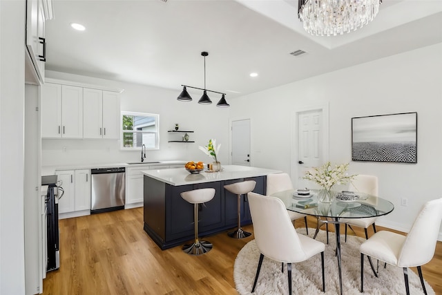 16731 Water Oak Dr, Channelview, TX 77530 - kitchen featuring appliances with stainless steel finishes, a sink, white cabinetry, light wood-style flooring, and light countertops