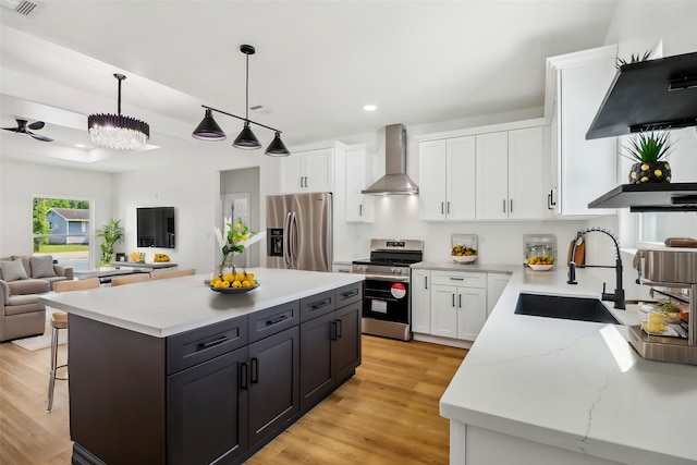 16731 Water Oak Dr, Channelview, TX 77530 - kitchen featuring stainless steel appliances, wall chimney range hood, a sink, open floor plan, and white cabinets