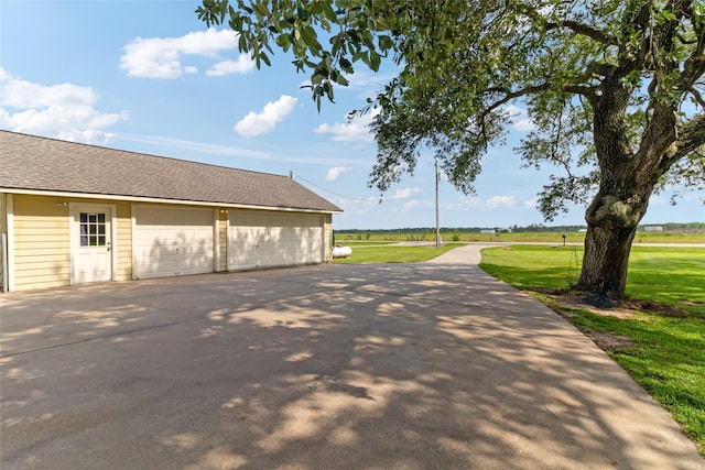 287 County Road 416, Brazoria, TX 77422 - view of home's exterior with a detached garage, a lawn, an outdoor structure, and a shingled roof