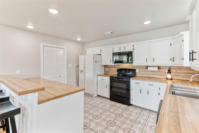 287 County Road 416, Brazoria, TX 77422 - kitchen featuring black appliances, a sink, a peninsula, white cabinetry, and tasteful backsplash
