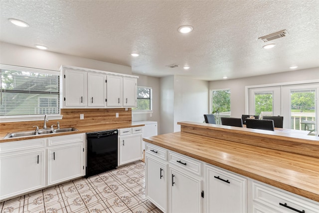 287 County Road 416, Brazoria, TX 77422 - kitchen with dishwasher, a sink, butcher block countertops, white cabinetry, and a textured ceiling