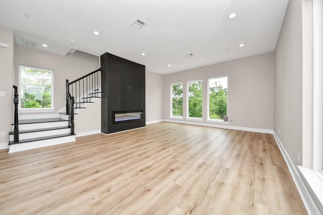 3913 Griggs Rd, Houston, TX 77021 - unfurnished living room featuring plenty of natural light, light wood-style flooring, stairway, and recessed lighting
