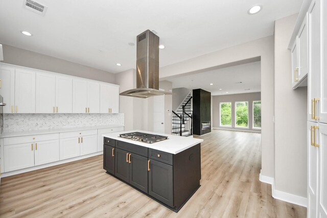 3913 Griggs Rd, Houston, TX 77021 - kitchen featuring island range hood, white cabinets, stainless steel gas stovetop, light countertops, and recessed lighting
