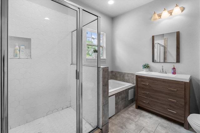 9307 Seeker St, Houston, TX 77028 - full bathroom featuring vanity, a garden tub, a stall shower, toilet, and tile patterned flooring
