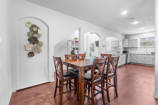 9307 Seeker St, Houston, TX 77028 - dining area with dark wood finished floors, arched walkways, and recessed lighting