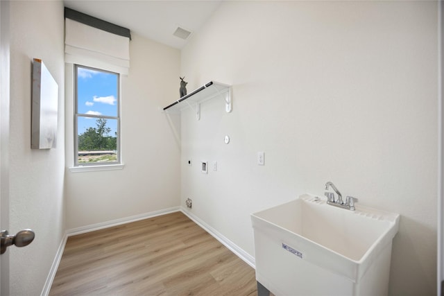 16800 Needlepoint Dr, Conroe, TX 77302 - washroom featuring hookup for a washing machine, baseboards, light wood-style floors, gas dryer hookup, and hookup for an electric dryer
