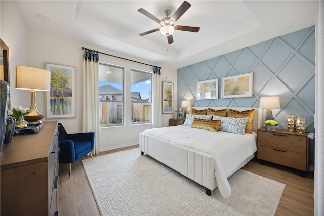 16800 Needlepoint Dr, Conroe, TX 77302 - bedroom with a tray ceiling, wood finished floors, baseboards, and ceiling fan