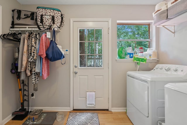2828 S Logrun Cir, The Woodlands, TX 77380 - laundry area with washer and dryer, healthy amount of natural light, light wood-style flooring, and baseboards