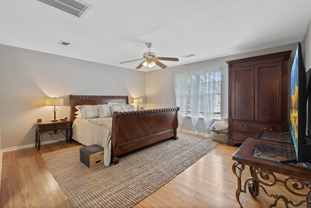 2828 S Logrun Cir, The Woodlands, TX 77380 - bedroom with light wood-style flooring, baseboards, and a ceiling fan