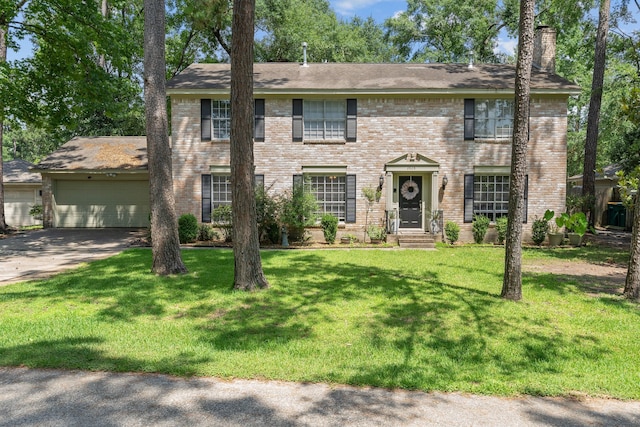 2828 S Logrun Cir, The Woodlands, TX 77380 - colonial inspired home featuring a chimney, an attached garage, concrete driveway, a front lawn, and brick siding