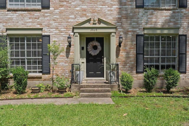2828 S Logrun Cir, The Woodlands, TX 77380 - view of exterior entry featuring a lawn and brick siding