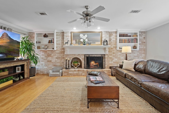 2828 S Logrun Cir, The Woodlands, TX 77380 - living area with wood finished floors, a fireplace, a ceiling fan, ornamental molding, and built in shelves