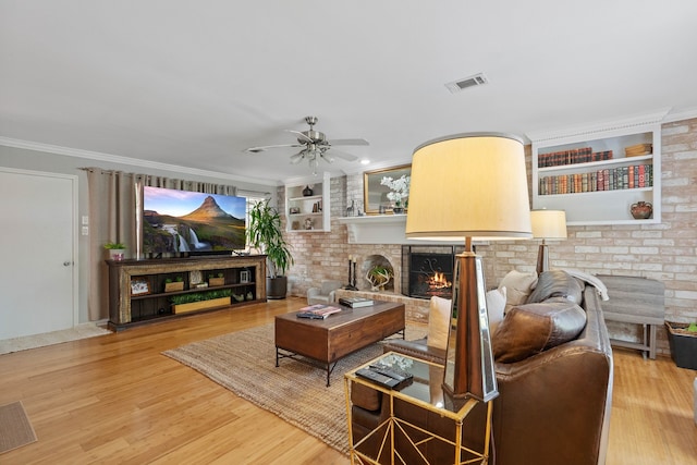 2828 S Logrun Cir, The Woodlands, TX 77380 - living area featuring wood finished floors, a ceiling fan, a fireplace, built in shelves, and ornamental molding